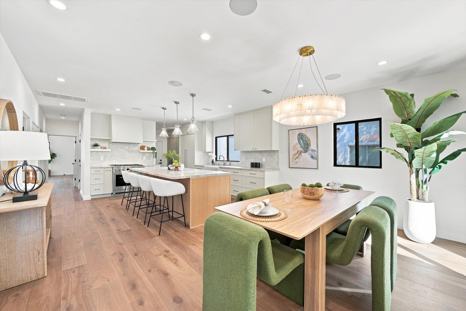 Kitchen and dining room at 9127 Hargis Street, Beverlywood Vicinity, Los Angeles, with a white oak island and green dining chairs