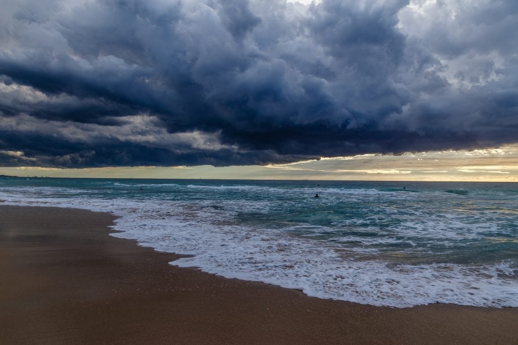 Dark storm clouds building over a beach and shoreline