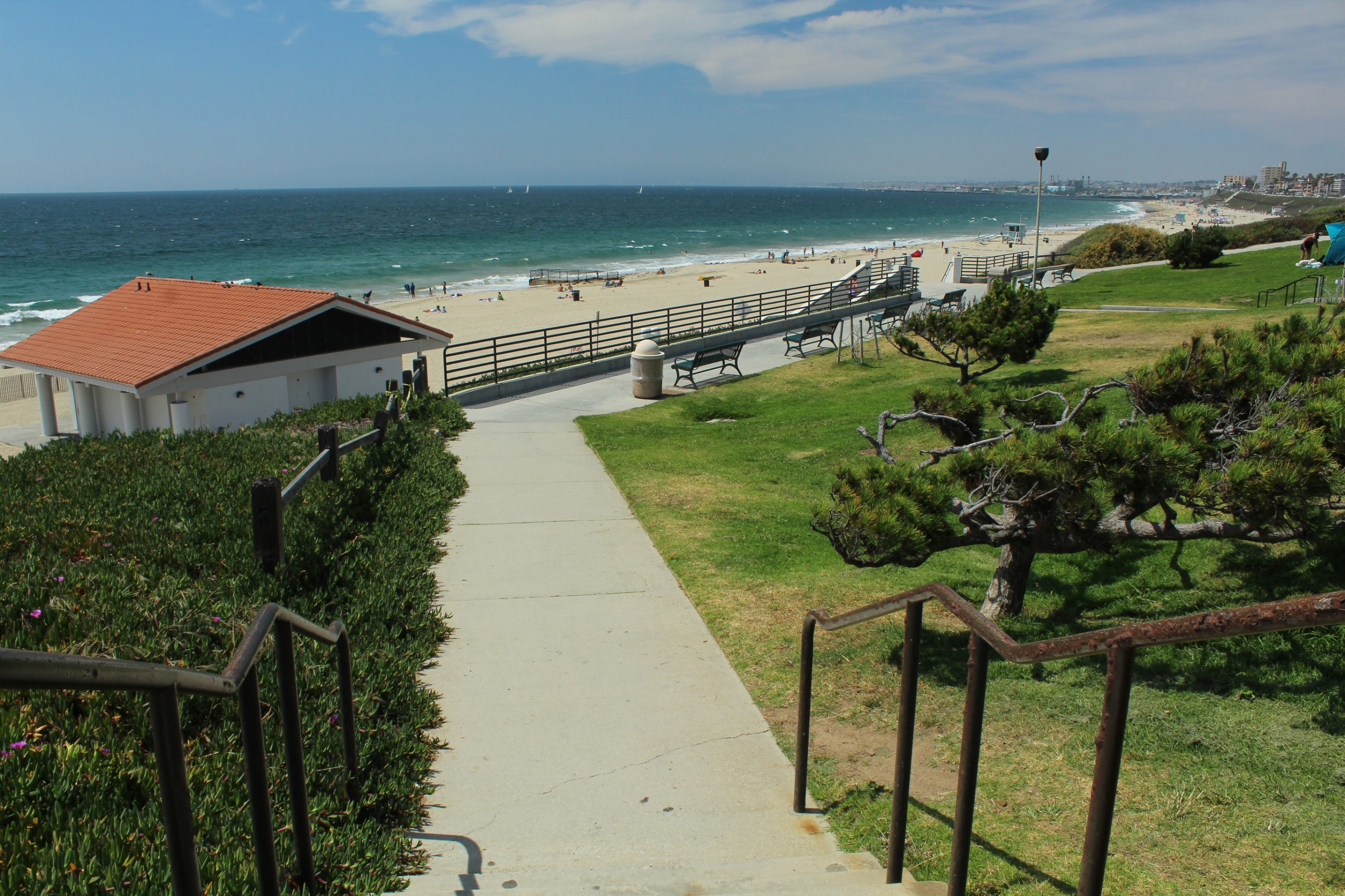 Grass lawn and path in a City of Torrance park with the shoreline beyond