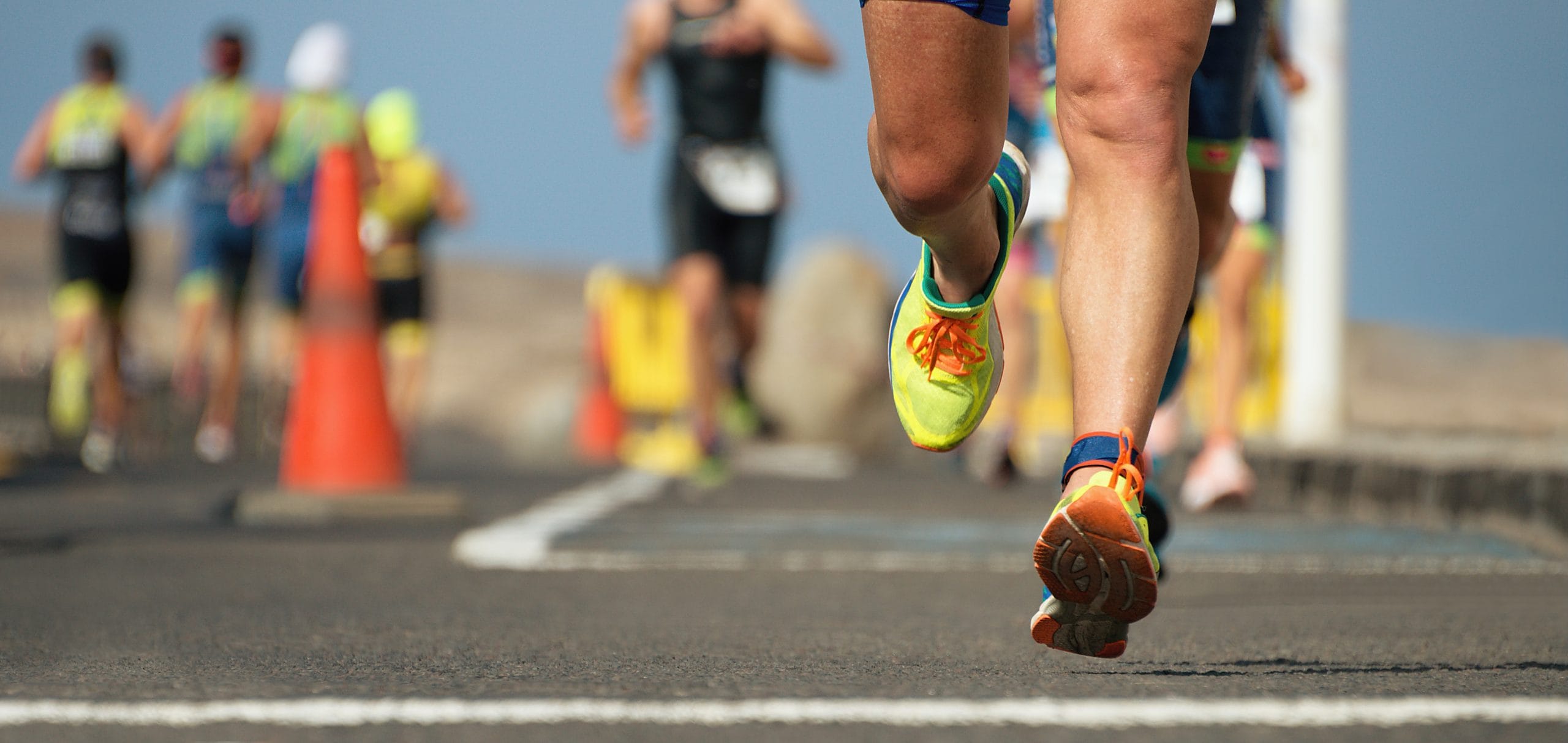 Close view of runners legs and running shoes during a road race