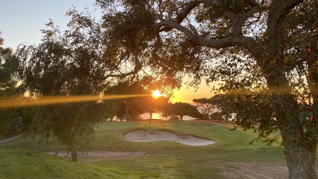 Golf course fairway and bunker framed by trees at sunset on the Palos Verdes Peninsula