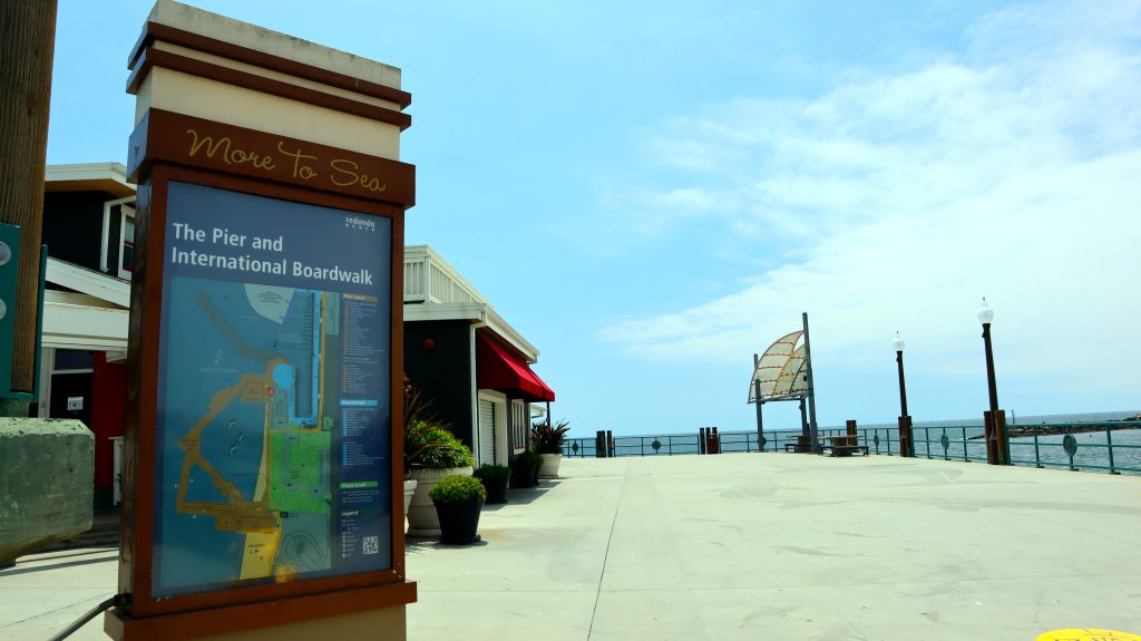 Visitor information board on the Redondo Beach boardwalk looking out toward the pier