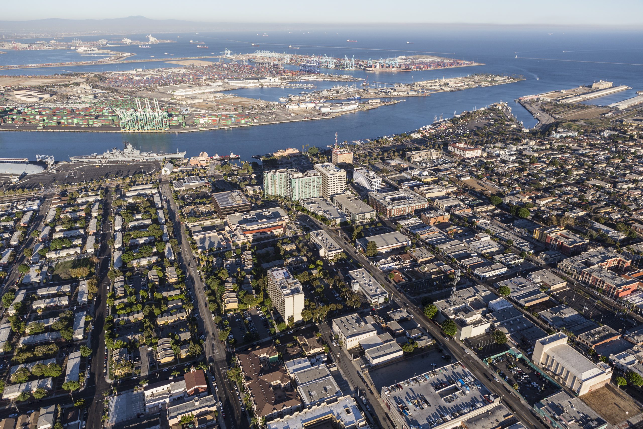 Aerial view over downtown San Pedro toward the Main Channel, the Battleship Iowa and the Port of Los Angeles container terminals on Terminal Island