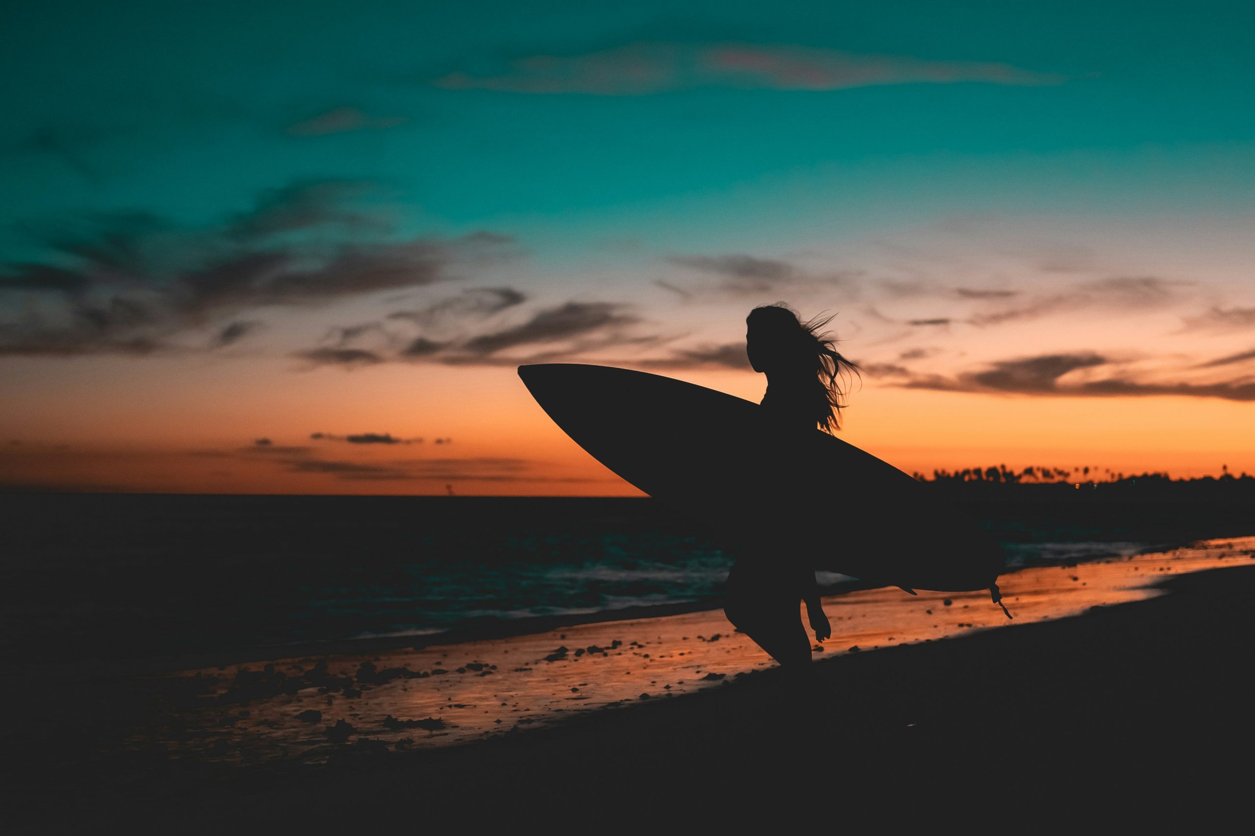 Surfer at sunset on the South Bay coastline of Los Angeles