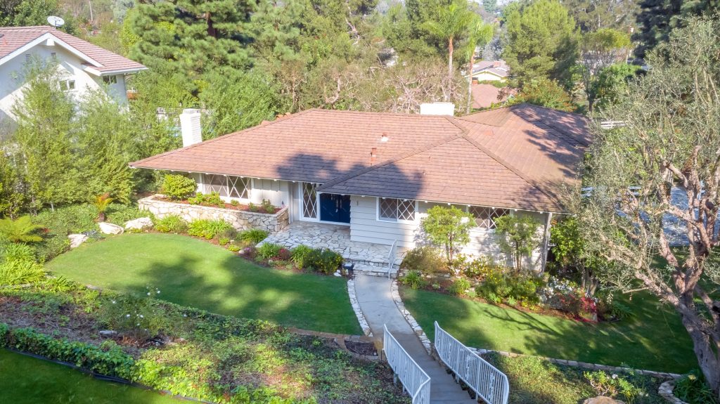 Aerial view of a single-story ranch home with a stone walkway and mature trees, Rolling Hills Estates
