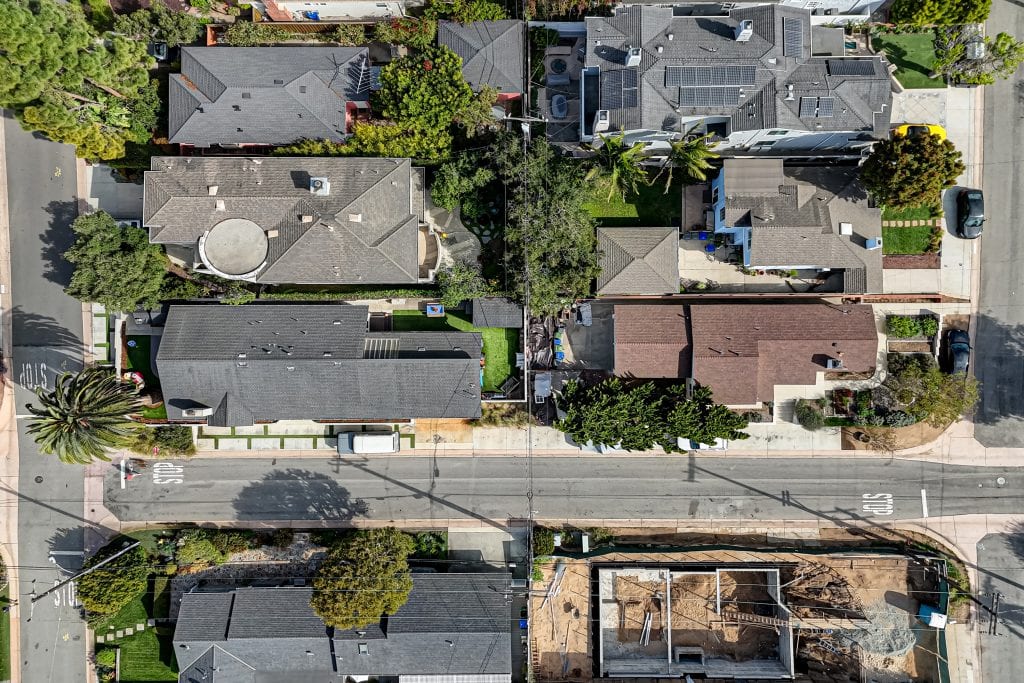Overhead aerial view of 2700 Elm Avenue and 2701 Oak Avenue in the Manhattan Beach Tree Section, two single-story houses on back-to-back lots along 27th Street, with a large palm at the Elm Avenue corner.